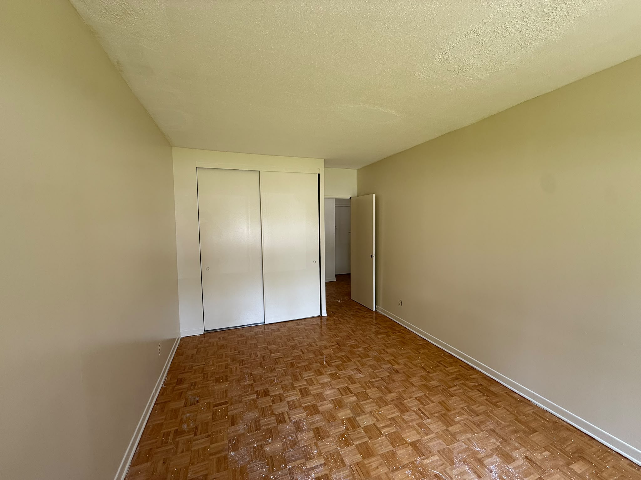 Apartment bedroom after painting — bright white walls with closets