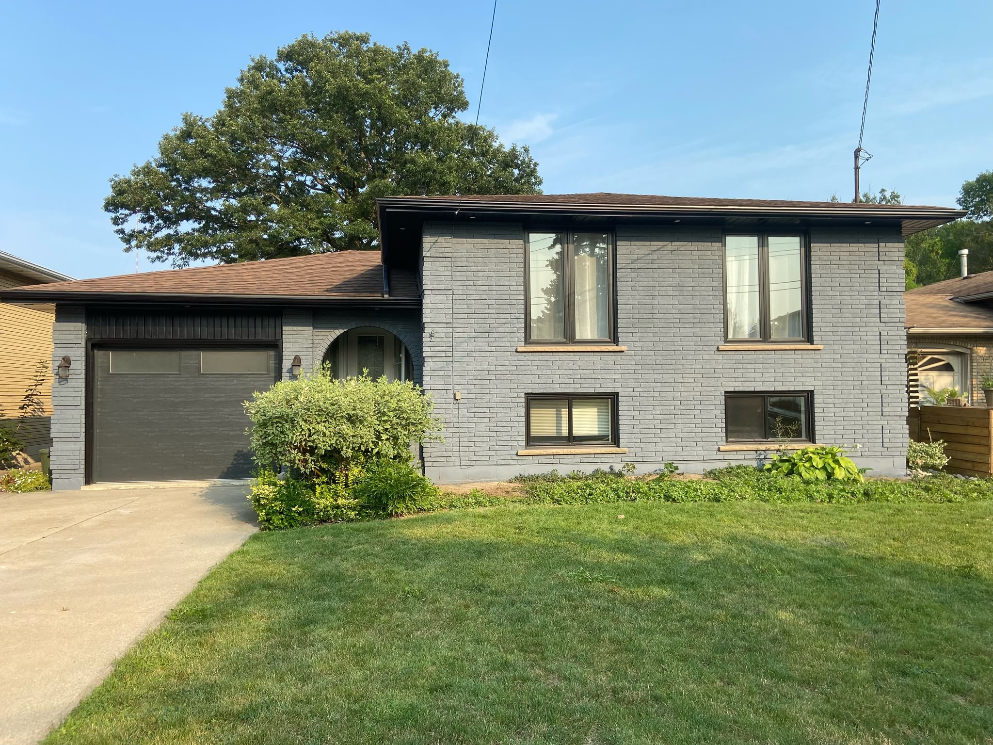 Barrhaven home exterior after painting — fresh charcoal grey painted brick with updated curb appeal
