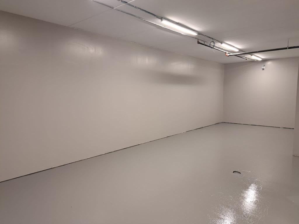 Commercial utility room after painting — clean white walls and painted floor