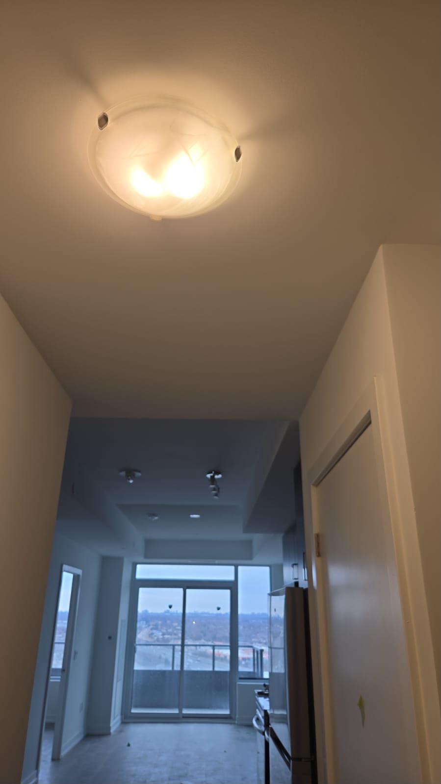 Condo unit hallway after painting — crisp white walls and ceiling with city views