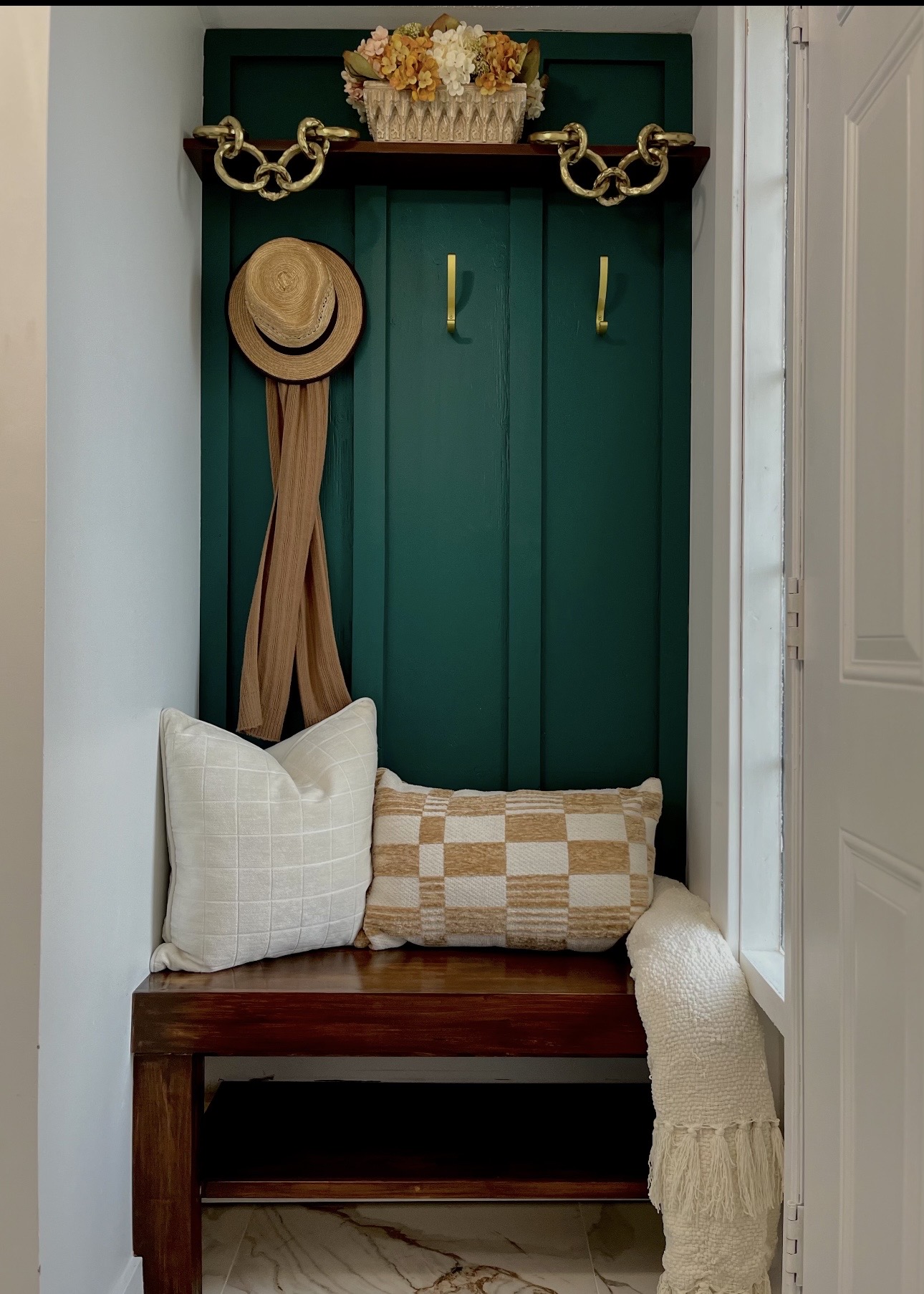 Mudroom after painting — deep green feature wall with stained bench
