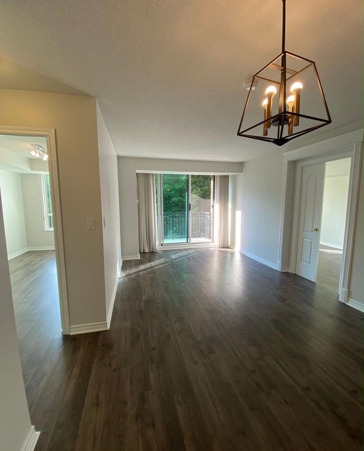 Residential open-concept living room finished — neutral walls, hardwood floors, chandelier