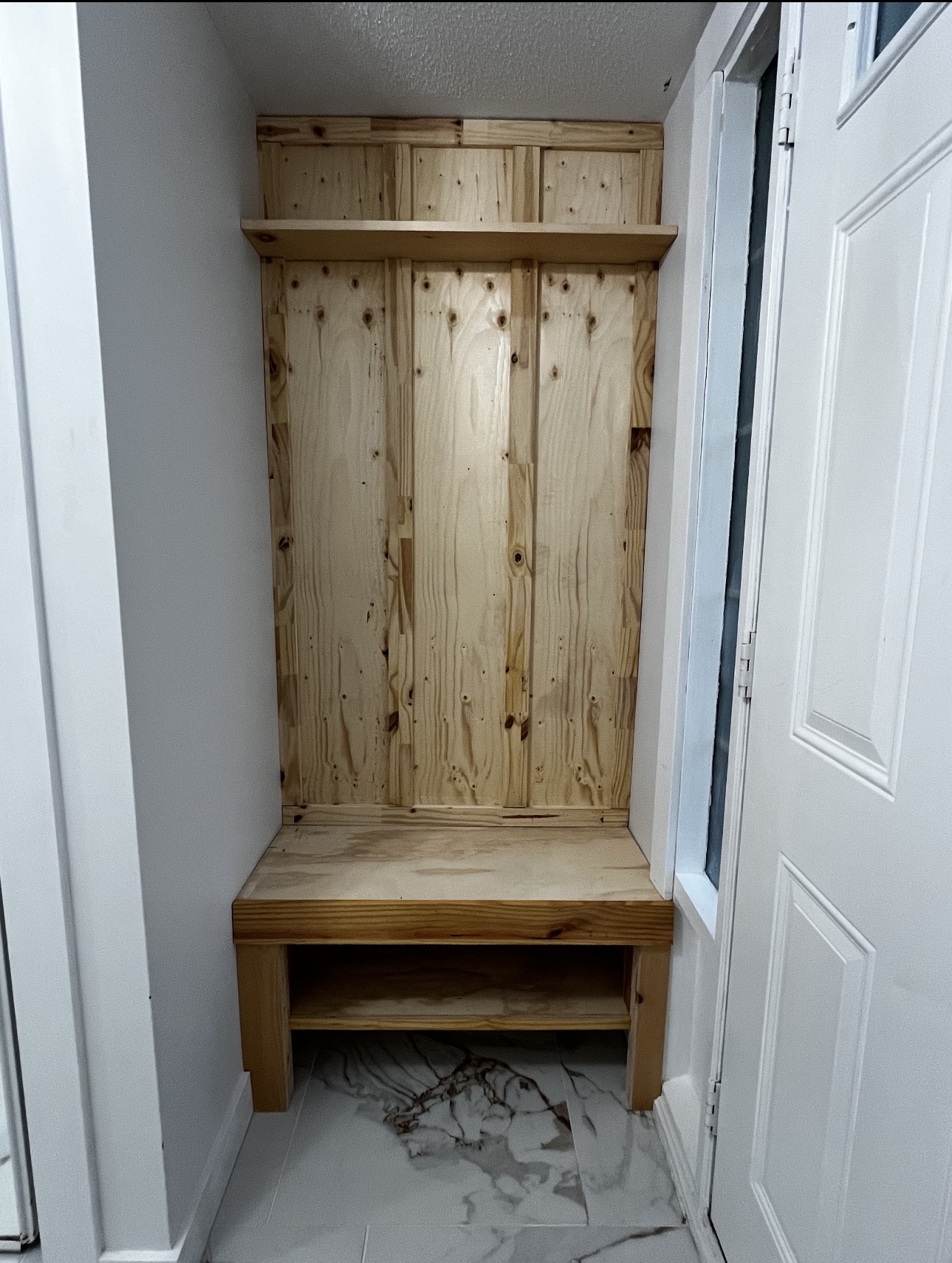 Mudroom built-in bench before painting — raw unfinished wood