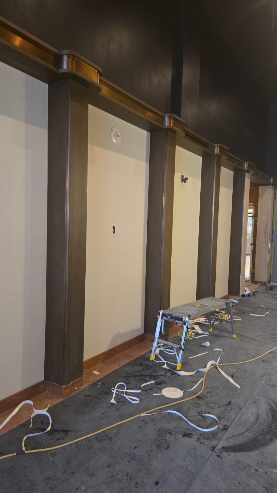 Commercial lobby painting in progress — dark ceiling and trim work underway