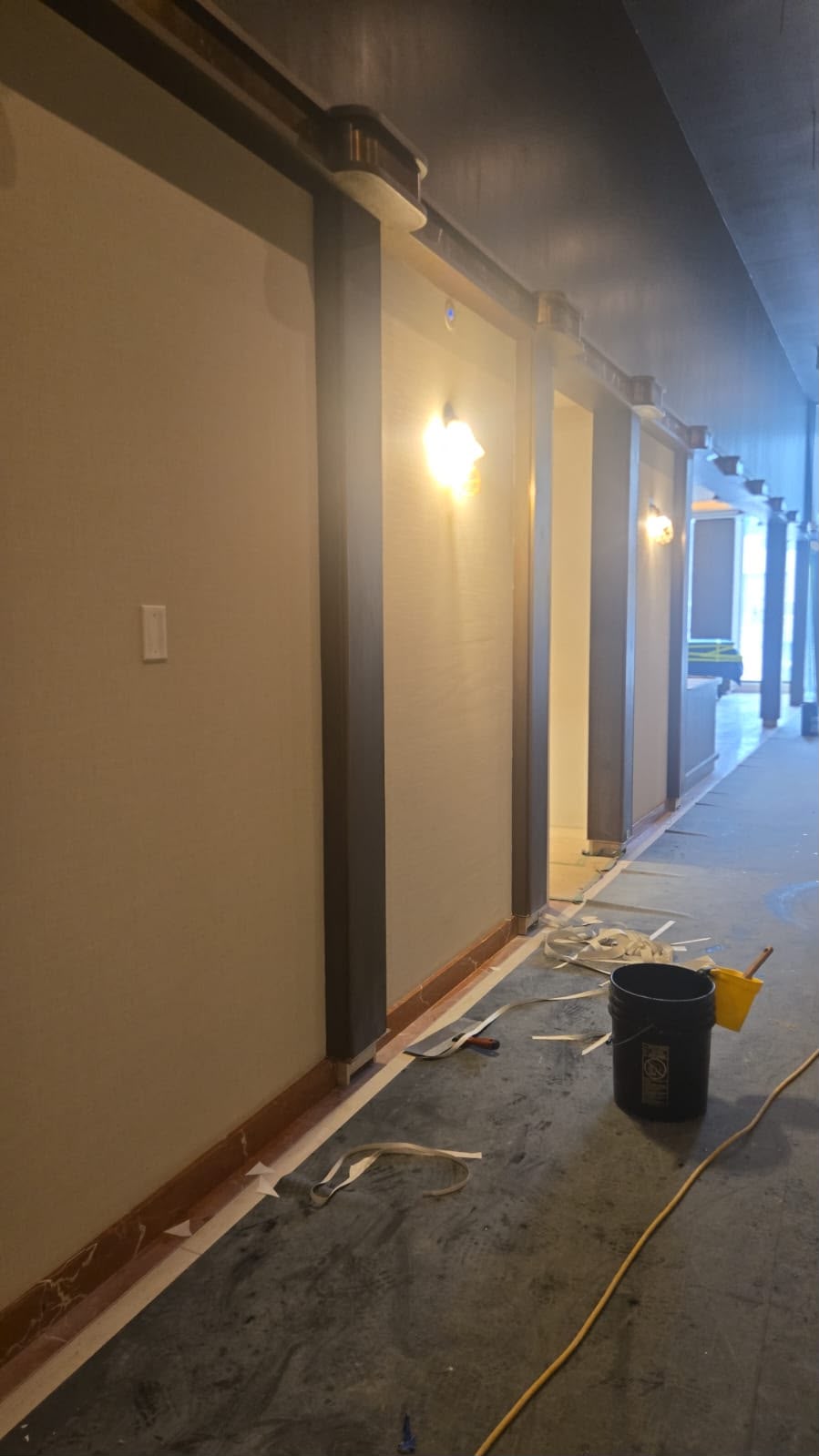 Commercial lobby hallway painting in progress — illuminated corridor