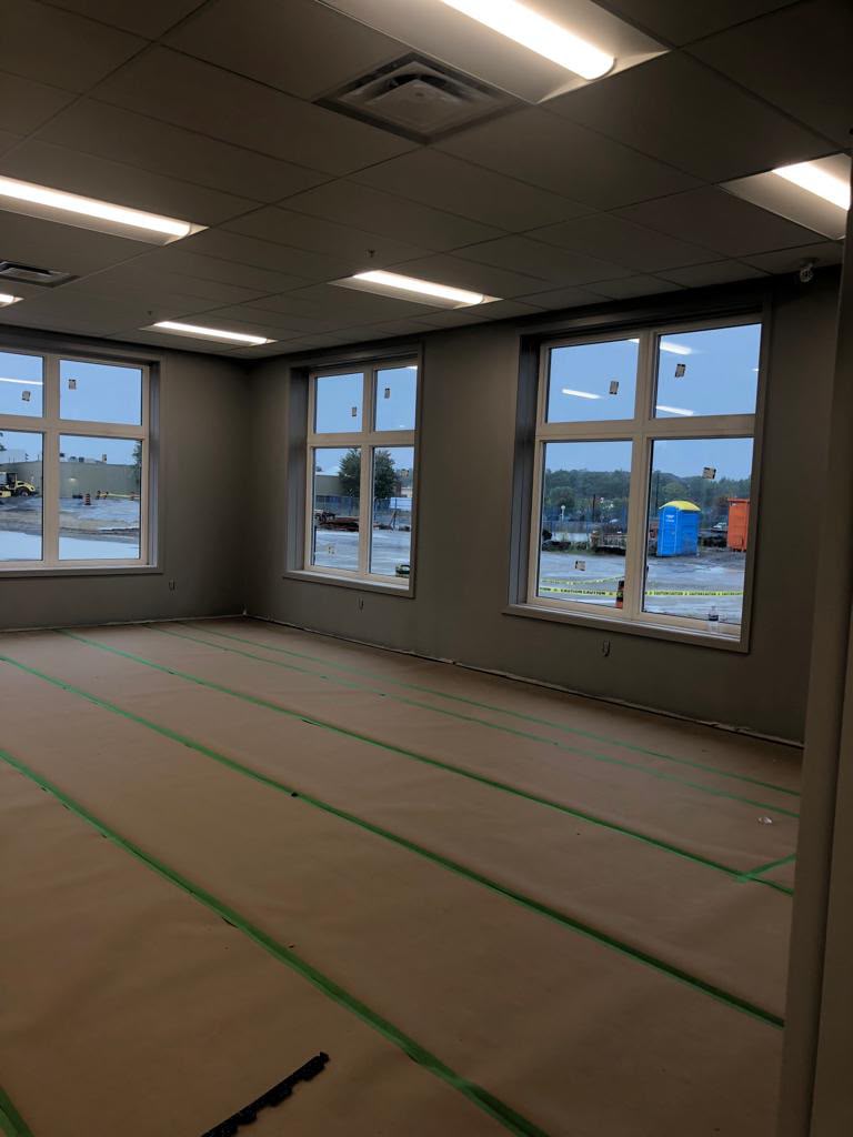 Commercial office space during painting — dark grey walls with protected floors